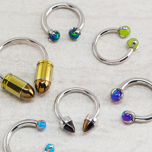 A close-up of titanium piercing jewelry on a soft fabric background, highlighting its hypoallergenic qualities.